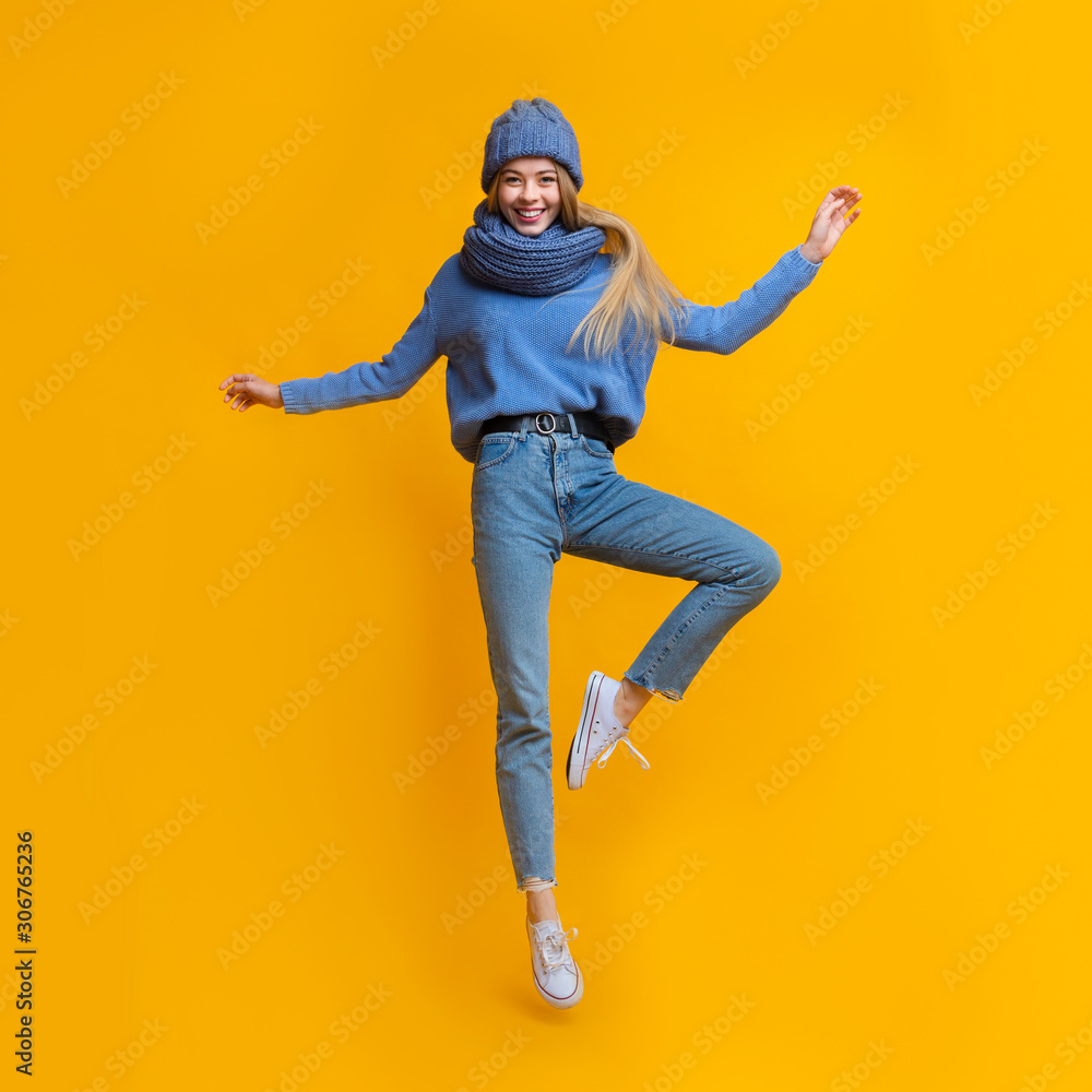Young beautiful girl in warm clothes jumping up Young beautiful girl in warm clothes jumping up