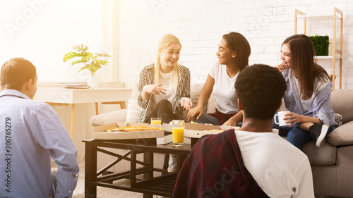 Friends having small home party. Teens eating pizza