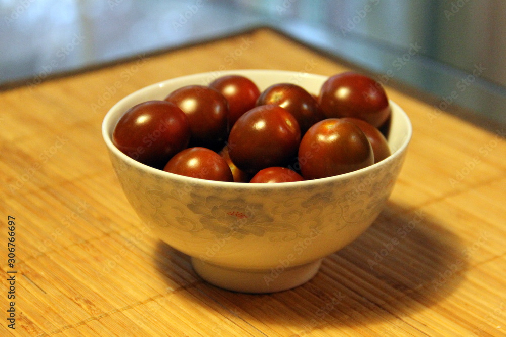 Small dark tomatoes in a white bowl Small dark tomatoes in a white bowl
