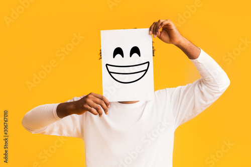 African american man holding paper with smiley face photo