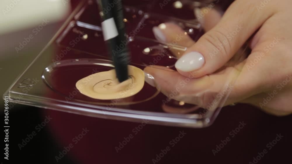 Professional makeup artist woman stirs makeup cream on a palette. Professional makeup artist woman stirs makeup cream on a palette.