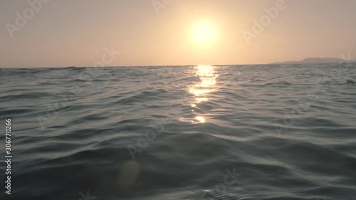 Sunset at sea, sun reflection on water surface. Ocean waves at sunset