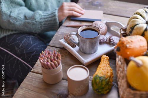 Autumn, pumpkins, hot steaming cup of coffee on a wooden table background. Seasonal, morning coffee, sunday relaxing and still life concept. Plans for the day.