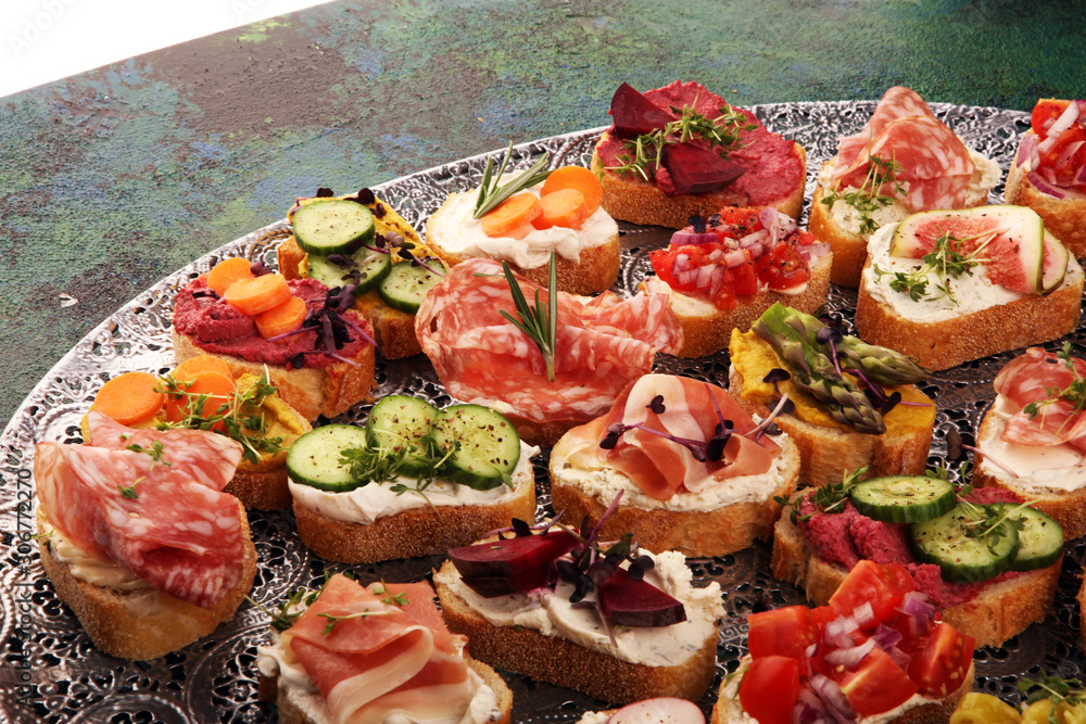 Assorted bruschetta with various toppings. Appetizing bruschetta or brie crostini. Variety of small sandwiches. Mix bruschetta on table