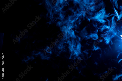 Whispy blue smoke on black background