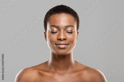 Beautiful afro woman with closed eyes, natural makeup and perfect skin