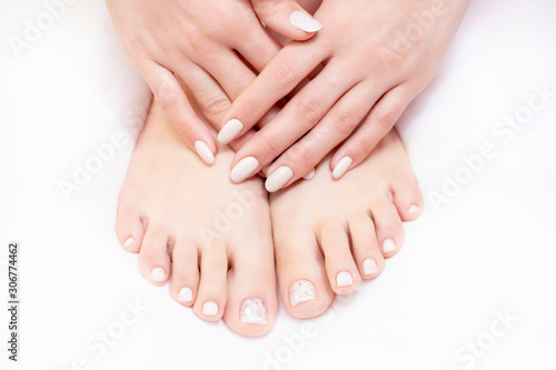 Closeup photo of female legs on a white towel in a spa salon on a pedicure and manicure procedure. nude colors. © Elena