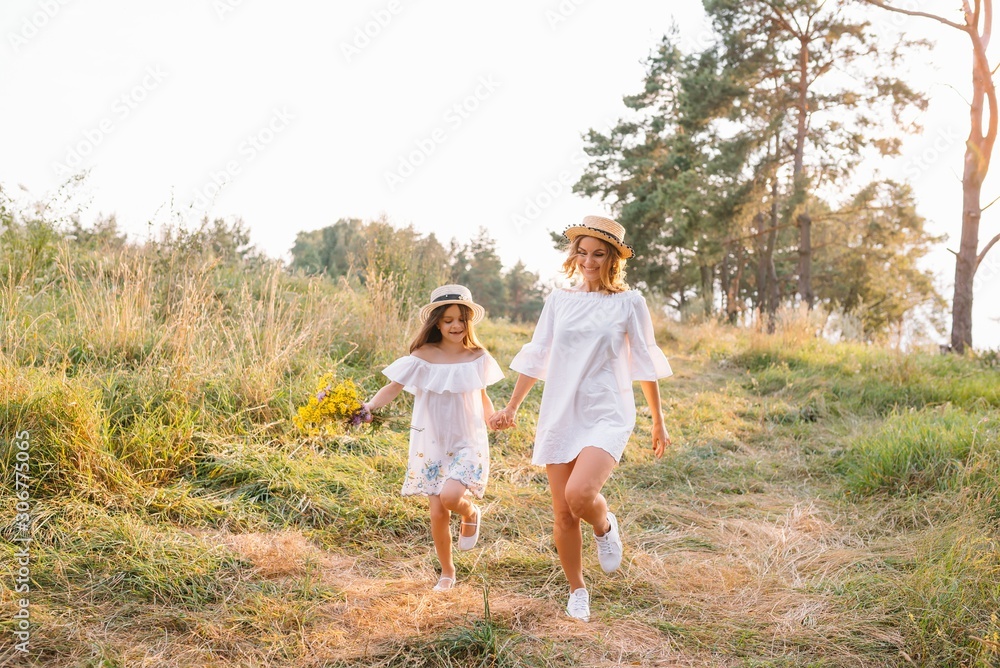 Mother and daughter having fun in the park. Happiness and harmony in family life. Beauty nature scene with family outdoor lifestyle. Mother's Day Mother and daughter having fun in the park. Happiness and harmony in family life. Beauty nature scene with family outdoor lifestyle. Mother's Day