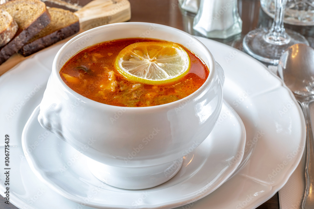 White bowl with hot soup hodgepodge served on the table of the restaurant. White bowl with hot soup hodgepodge served on the table of the restaurant.