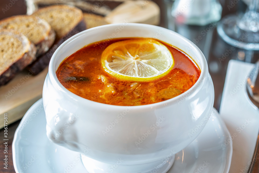 White ceramic bowl with a hot soup hodgepodge, served on the table of restaurant. White ceramic bowl with a hot soup hodgepodge, served on the table of restaurant.