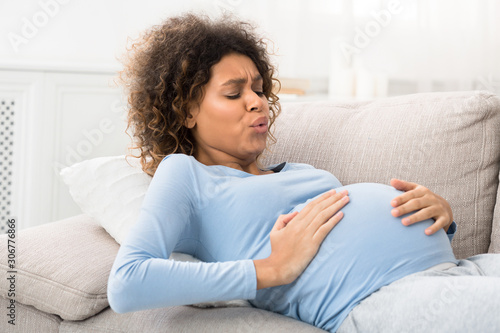 Expectant woman having contractions and doing breathing exercises photo