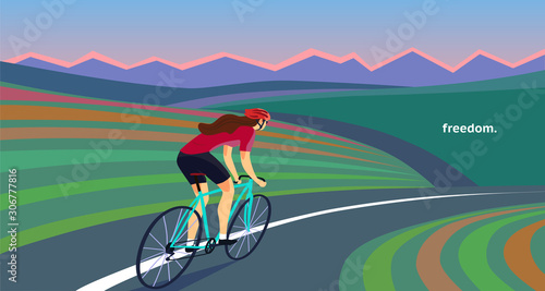 Woman cyclist riding on the road near the hills and mountains.