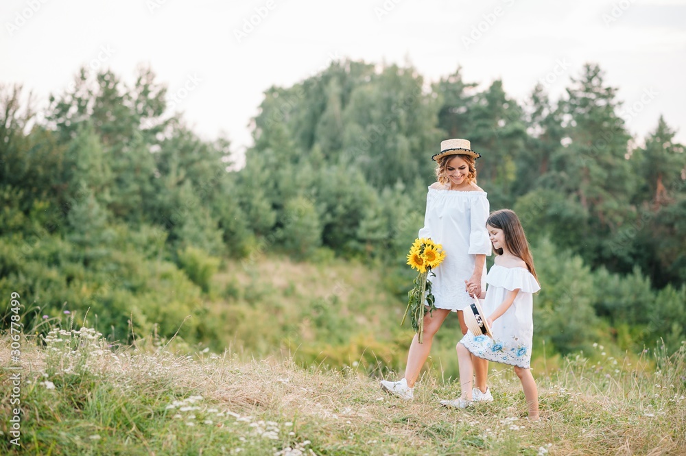 Stylish mother and handsome daughter having fun on the nature. Happy family concept. Beauty nature scene with family outdoor lifestyle. family resting together. Happiness in family life. Mothers day Stylish mother and handsome daughter having fun on the nature. Happy family concept. Beauty nature scene with family outdoor lifestyle. family resting together. Happiness in family life. Mothers day
