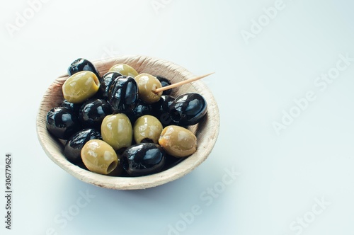 Olives in a bowl with copyspace on white background