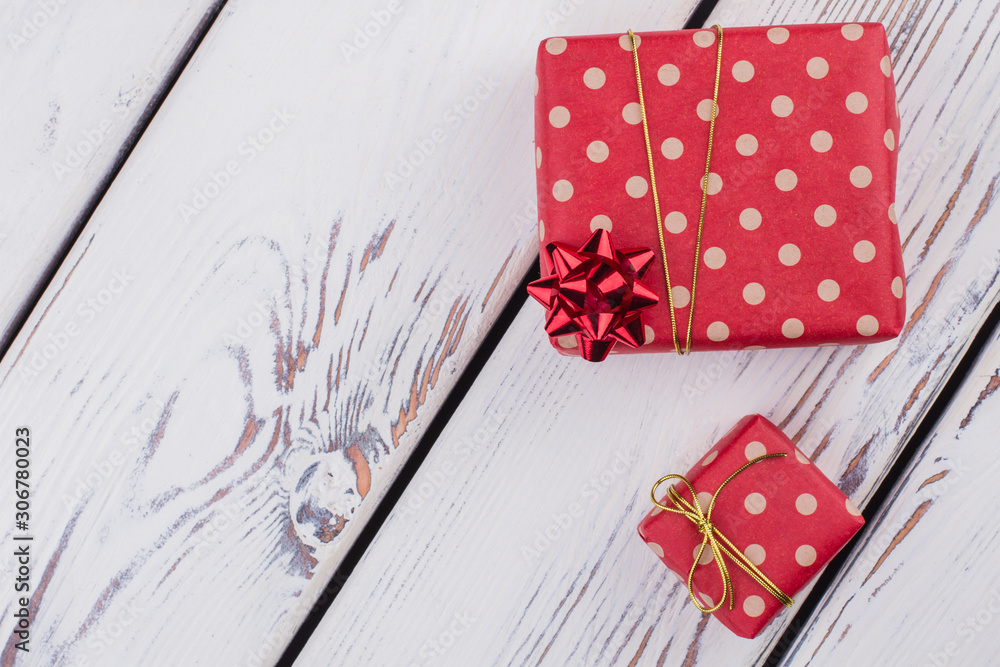 Obraz premium Christmas gift boxes and copy space. Gift boxes with ribbons on white wooden background with text space. Holiday celebration concept.