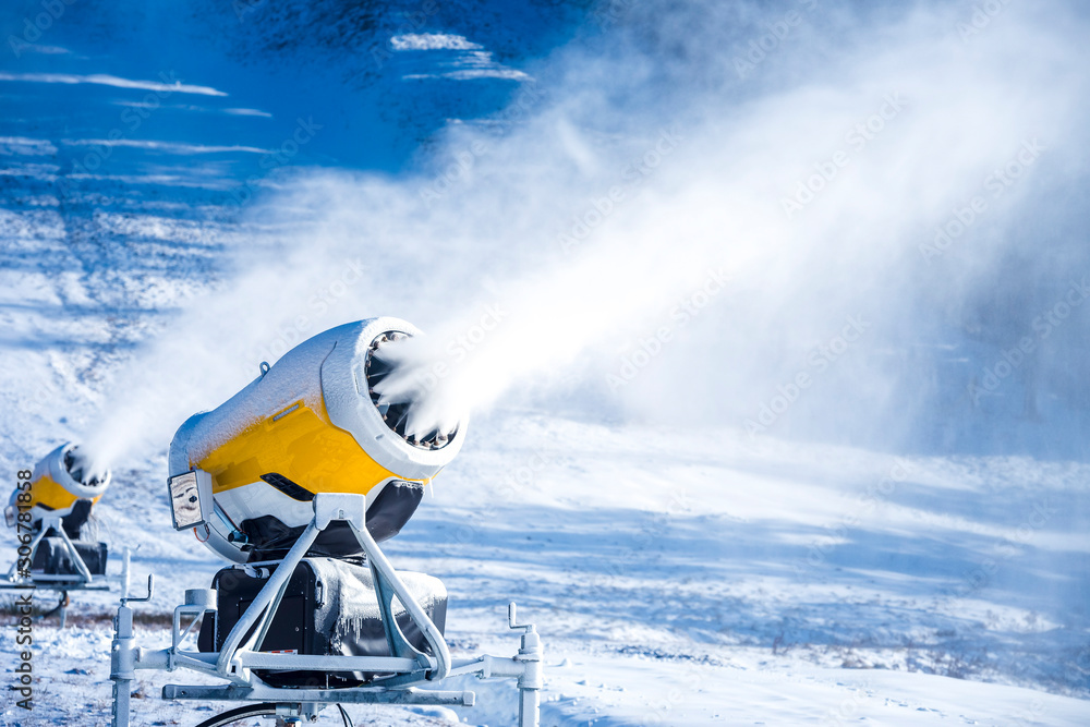 Snow cannon in winter mountains. Snow-gun spraying artificial ice crystals.  Machine making snow. Stock Photo