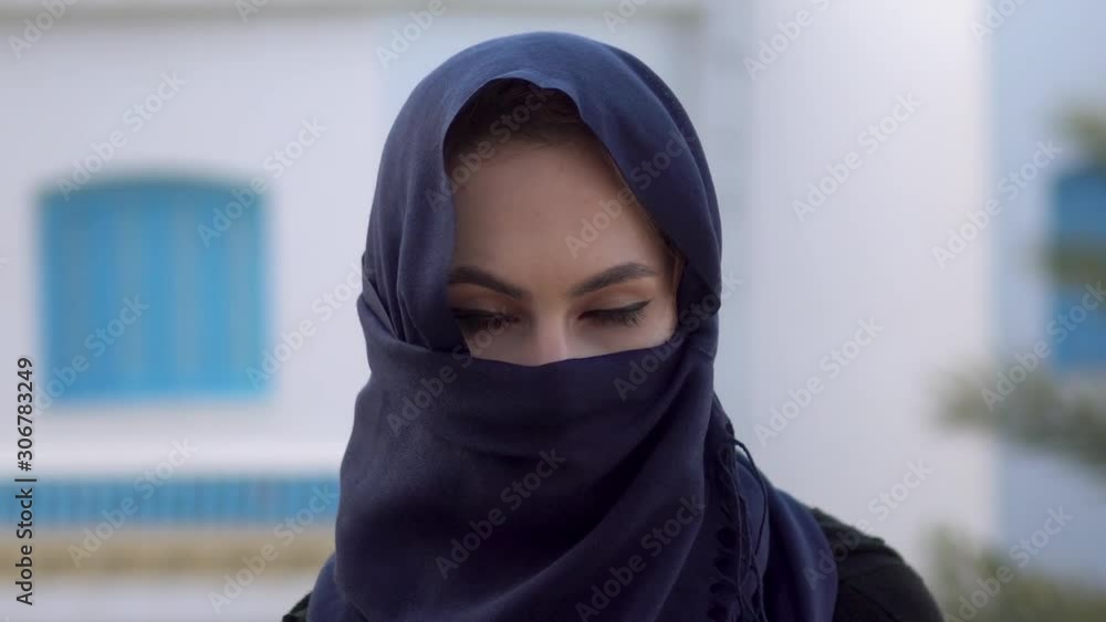 Young woman in arabic burqa. A woman is looking at the camera. Against the background of the Arab house. Young woman in arabic burqa. A woman is looking at the camera. Against the background of the Arab house.