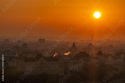Hazy morning and sunrise over Budapest and Eye ferris wheel.