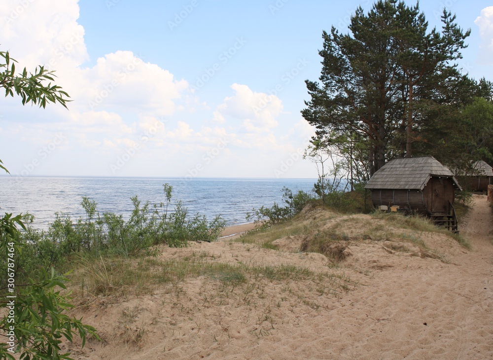 Coastal sand dunes and wooden Melnsils camping houses on the shores of the Gulf of Riga in Latvia. June 2019 Coastal sand dunes and wooden Melnsils camping houses on the shores of the Gulf of Riga in Latvia. June 2019