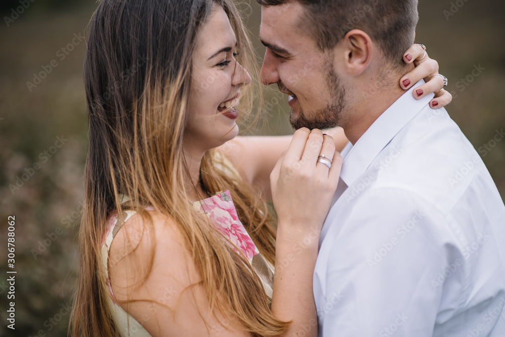 A girl and a guy are walking in the nature. Portrait of a couple, a love story.Happy smiling, loveing couple together outstretched at beautiful nature. Lovestory A girl and a guy are walking in the nature. Portrait of a couple, a love story.Happy smiling, loveing couple together outstretched at beautiful nature. Lovestory