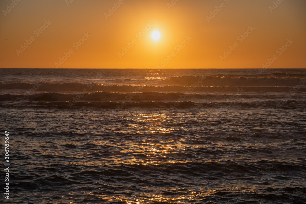 Bonito pôr do sol na praia com grandes ondas