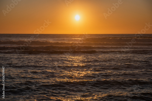 Bonito p  r do sol na praia com grandes ondas