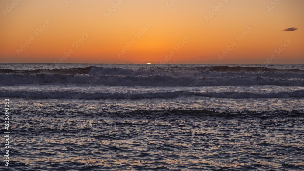 Bonito pôr do sol no mar com grandes ondas