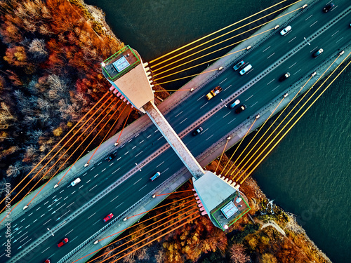 Obraz na płótnie Beautiful panoramic aerial drone view to cable-stayed Siekierkowski Bridge over the Vistula river and Warsaw City skyscrapers, Poland in gold red autumn colors in November evening at sunset - top down w salonie