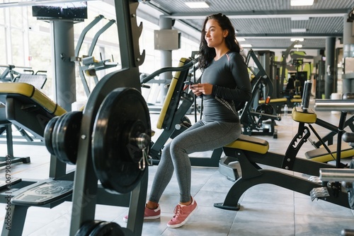 Gorgeous young woman texting and social networking while in a gym