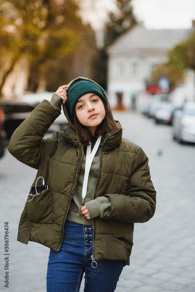 stylish beautiful teen girl on the street in a hat and jacket stylish beautiful teen girl on the street in a hat and jacket