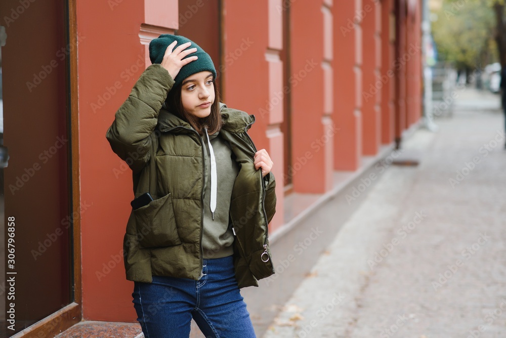 stylish teen girl outdoors in a hat and jacket