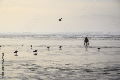 Beach at low tide with lonely person staring out at the Pacific Ocean, Ocean Shores, Washington State, USA