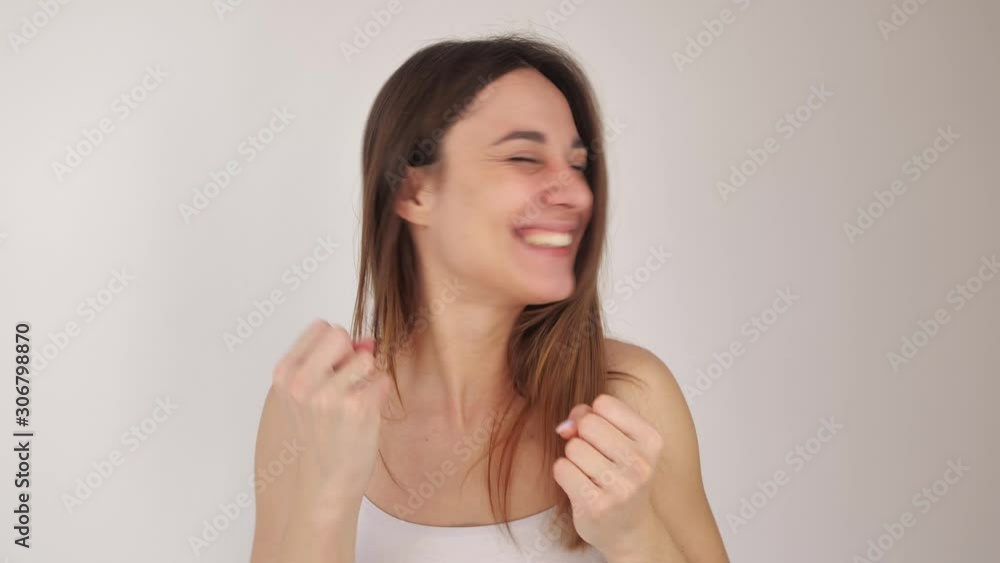 Young beautiful girl actively shows joy, smiles and waves her hands, having learned that she won the lottery. Portrait on a white background. 4k Young beautiful girl actively shows joy, smiles and waves her hands, having learned that she won the lottery. Portrait on a white background. 4k