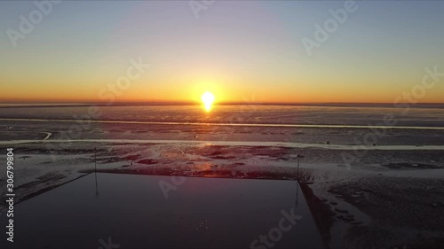 Drone footage over Shoeburyness garrison during sunrise in December birds flying tide out  bright sun stable photo