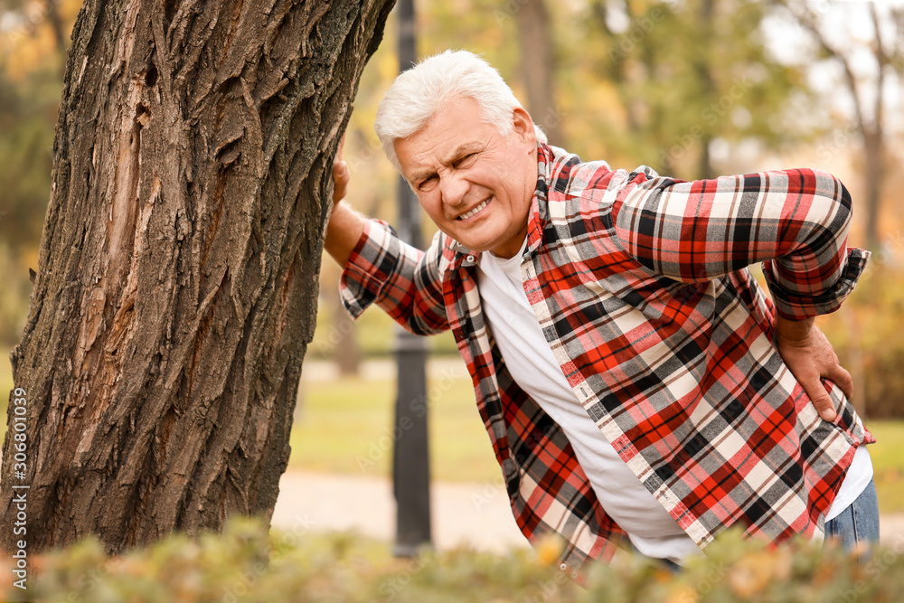 Senior man suffering from back pain outdoors