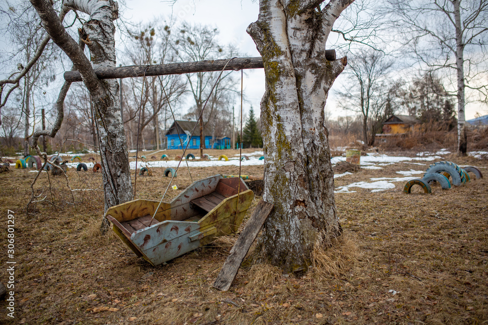 Russian village. Old wooden children's swing on a playground in the Russian village