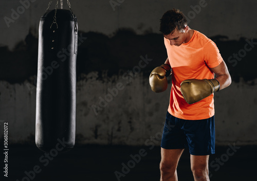 Silhouette muscular fighter training on a punching bag in the gym © qunica.com