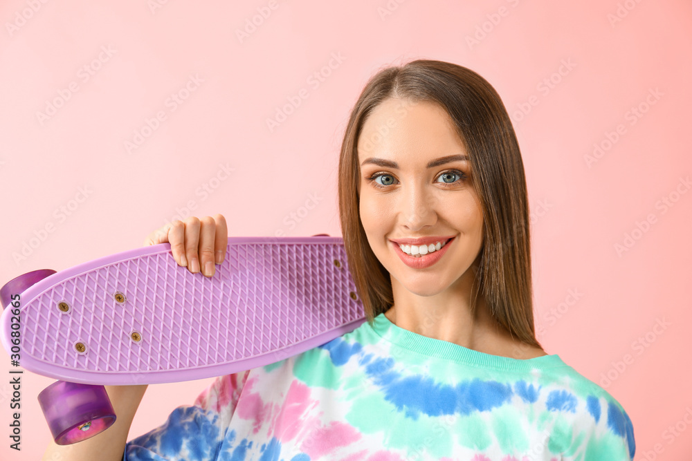 Beautiful young woman with skateboard on color background Beautiful young woman with skateboard on color background