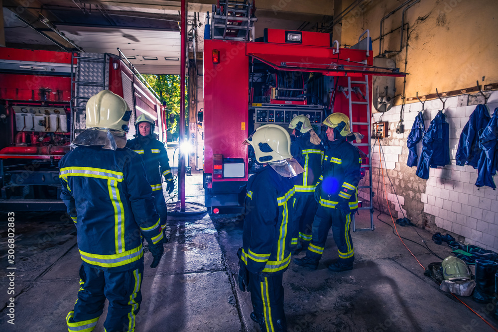 Group of firefighters preparing and inspecting pressure and water in the fire truck inside the fire station