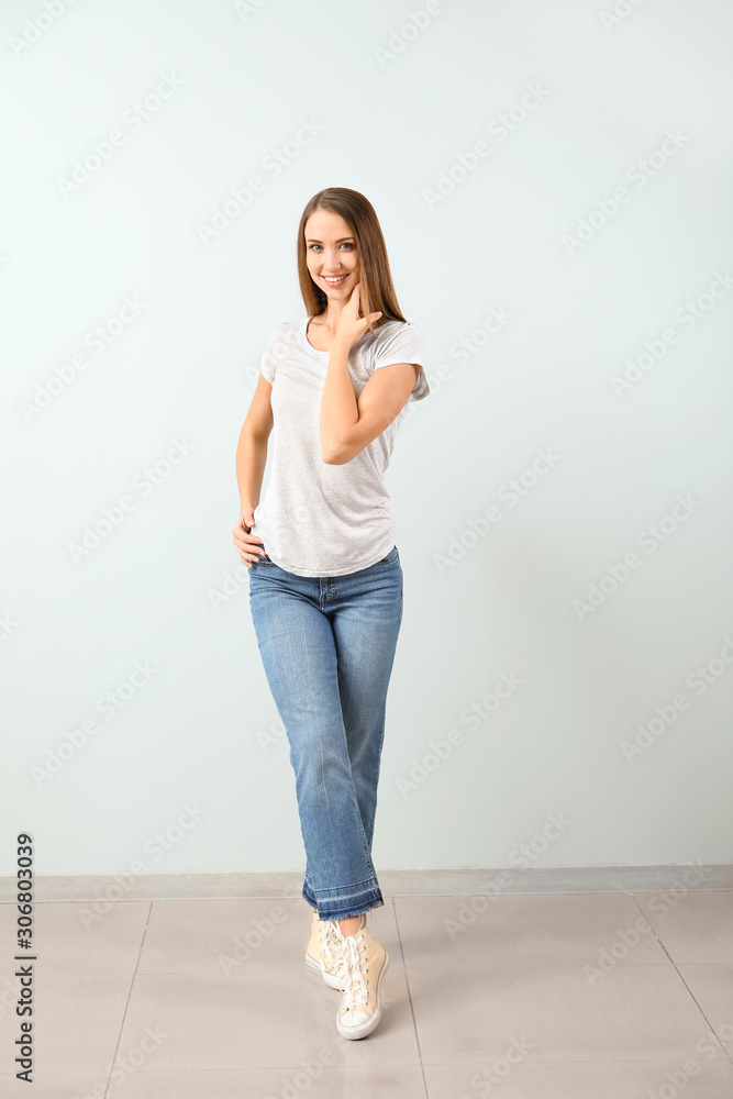 Beautiful young woman against light wall Beautiful young woman against light wall