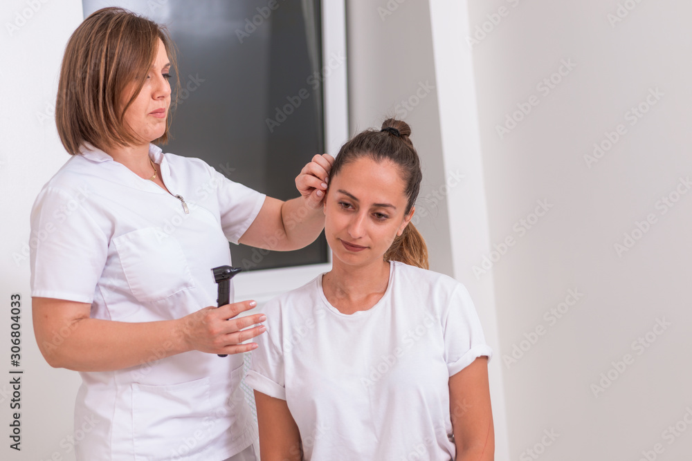 Doctor checking patients ear during medical examination Doctor checking patients ear during medical examination