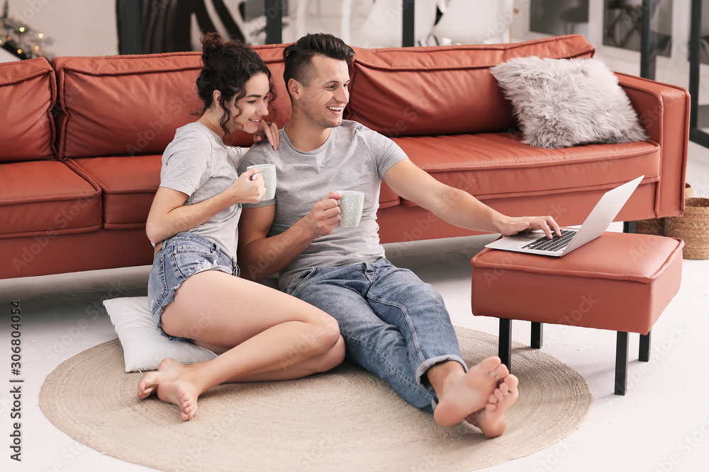 Happy young couple with laptop at home