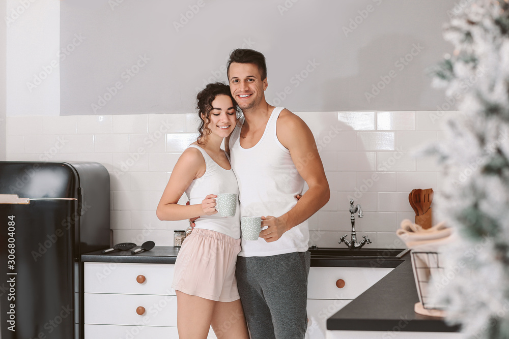Happy young couple in kitchen at home