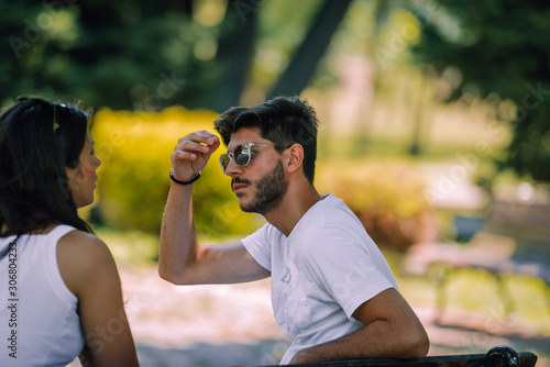 Portrait of smiling couple sitting in park and talking photo