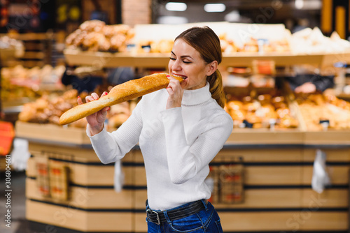 Cute Frenchwoman in a striped T-shirt holding a baguette in the hands