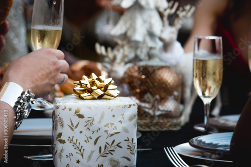 glass of Champagne in restaurant with Christmas gift on the table xmas party