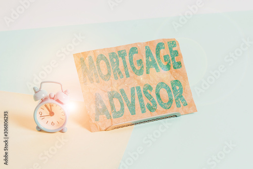 Text sign showing Mortgage Advisor. Business photo text specialist or broker with indepth knowledge of the market Mini size alarm clock beside a Paper sheet placed tilted on pastel backdrop