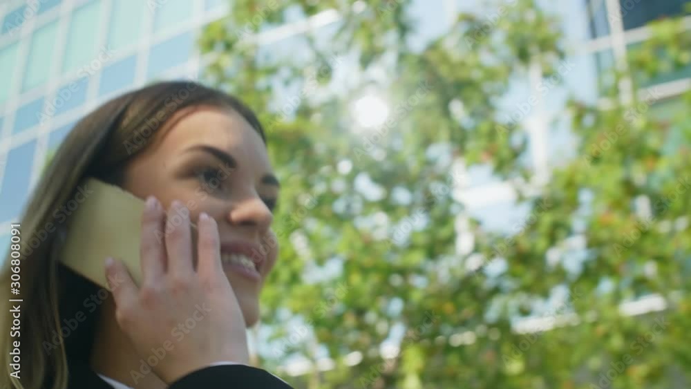 Close up shot of businesswoman going through downtown and talking on smartphone with her colleague Close up shot of businesswoman going through downtown and talking on smartphone with her colleague