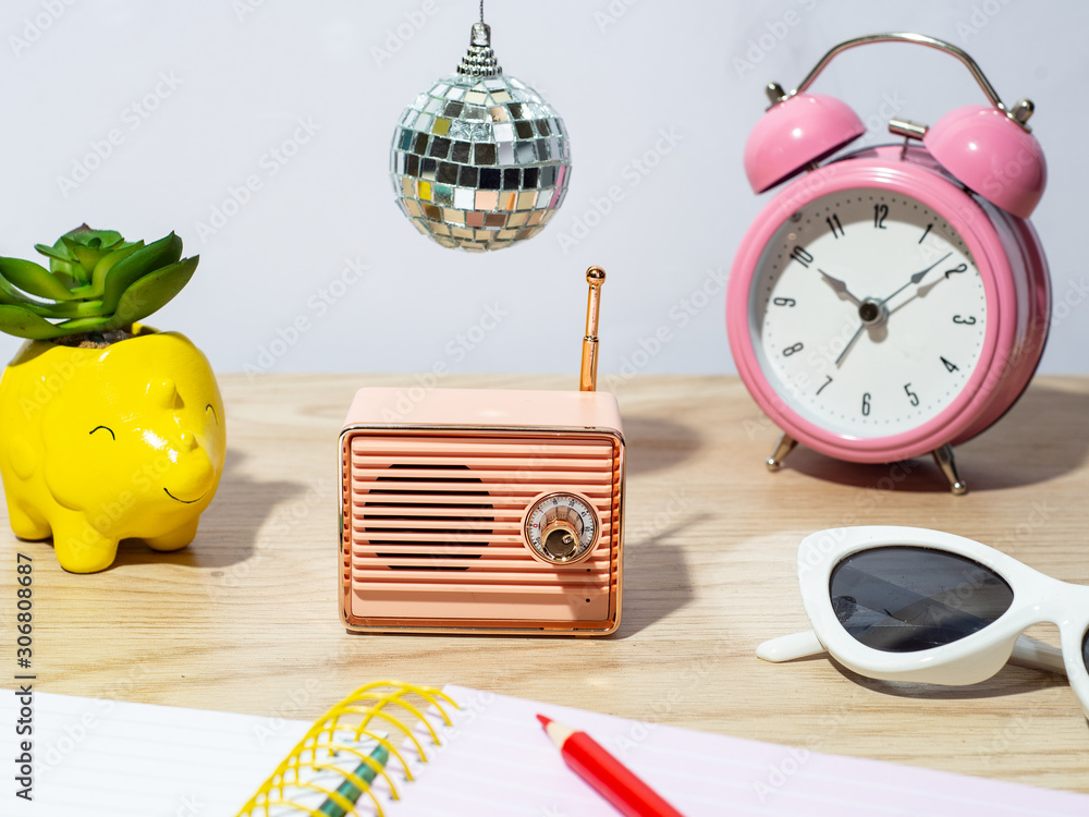 a pink retro radio on a wooden desk with a disco ball hanging over it Stock  Photo | Adobe Stock