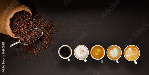 Variety of cups of coffee and coffee beans in burlap sack on black background.